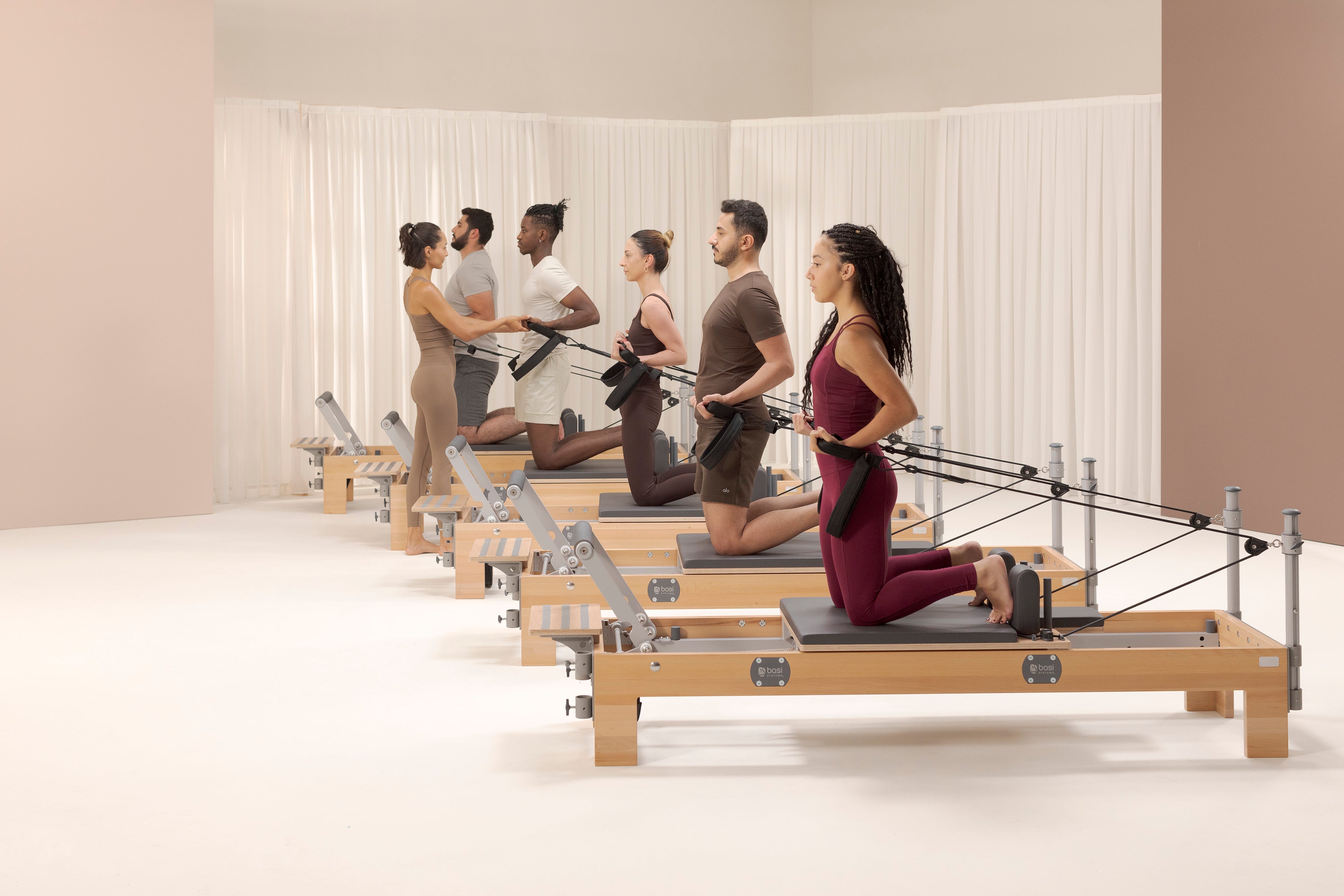 People practicing Pilates on a BASI Compact Reformer